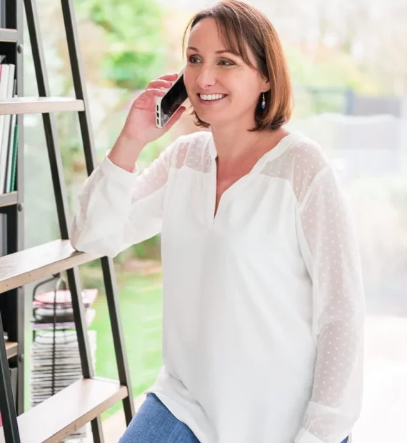 Maud Lepierre au téléphone avec un parent, devant sa bibliothèque